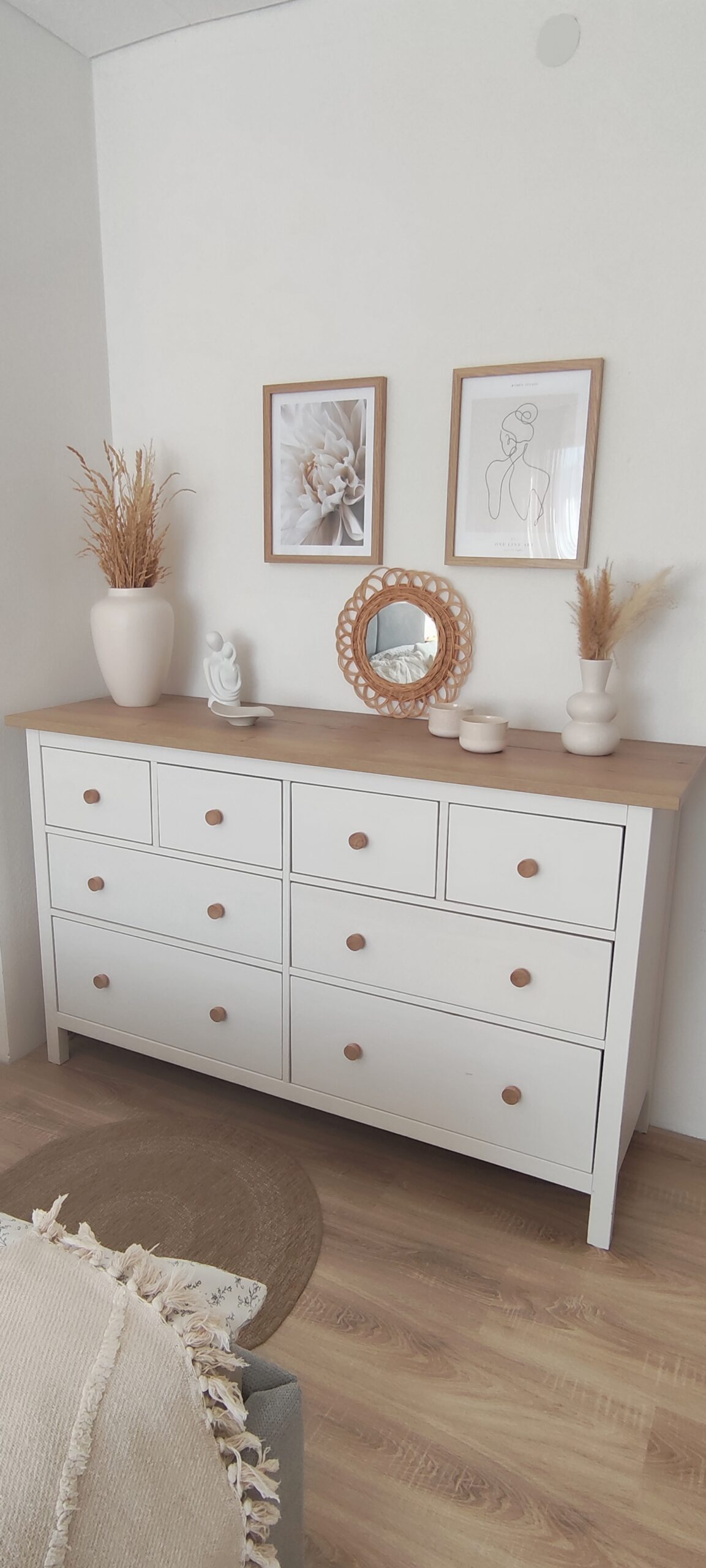 Weiße Kommode mit heller Holzplatte und Dekoration