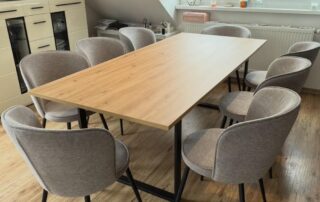 Esszimmer mit Esstisch mit heller Holzplatte und grauen Stühlen