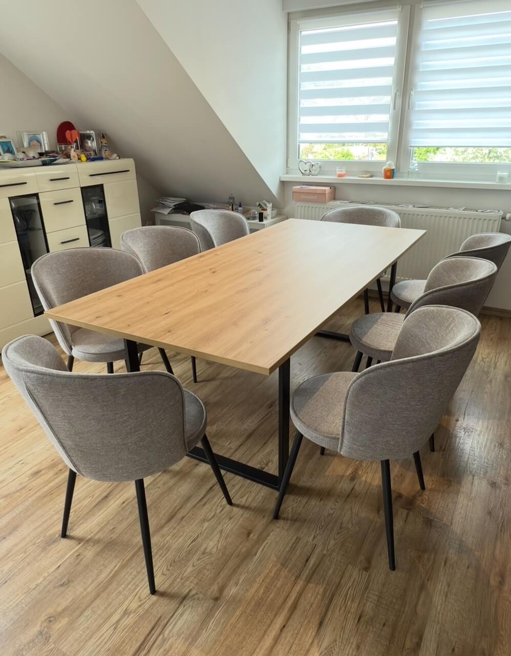 Esszimmer mit Esstisch mit heller Holzplatte und grauen Stühlen