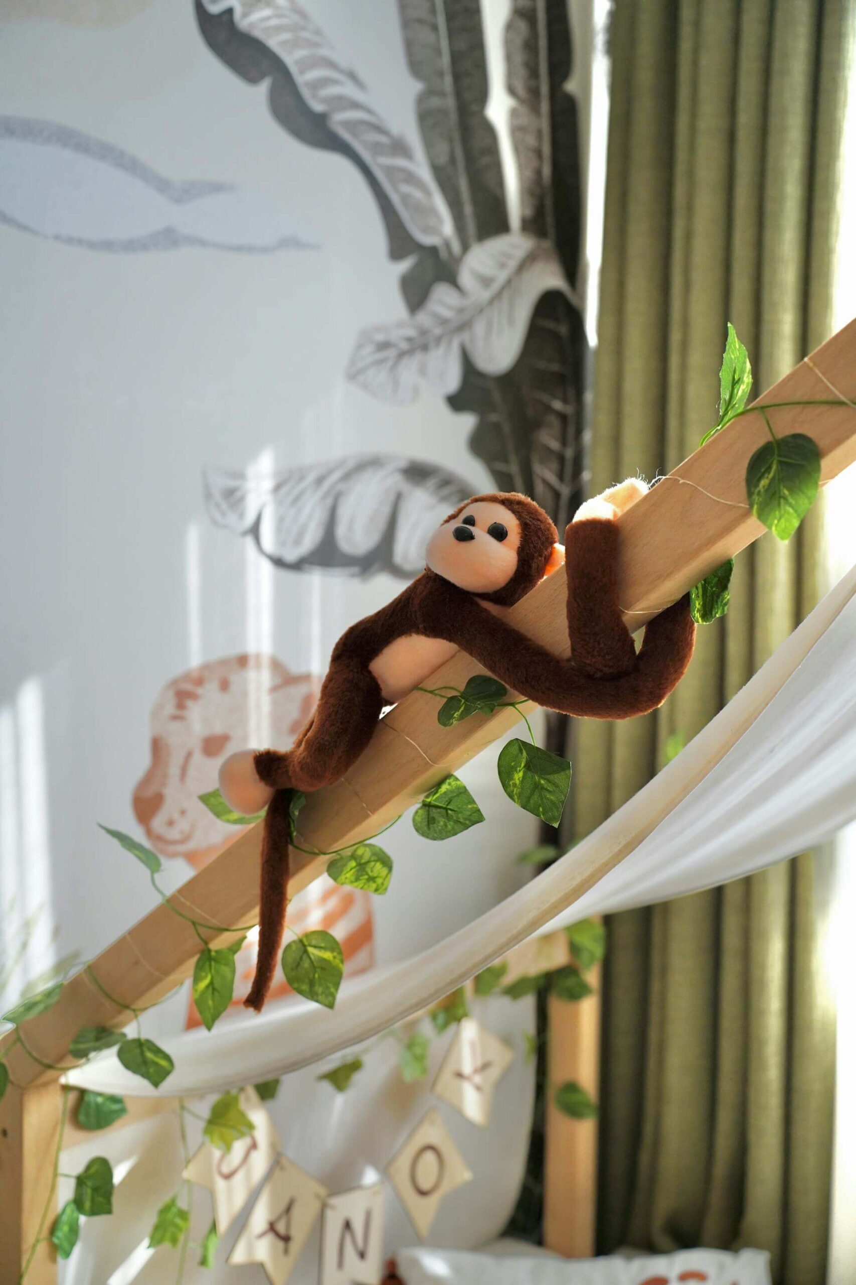 Kuscheltier Affe in einem Kinderzimmer mit dem Thema Dschungel
